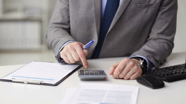 close up of businessman with papers and calculator