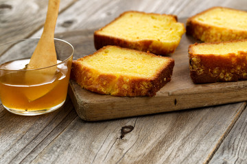 Fresh Slices of Lemon Cake and honey on wood server