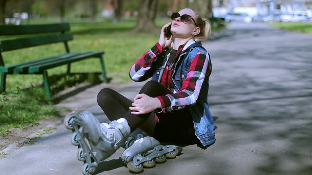 Girl talking on cellphone after accident on rollerblades
