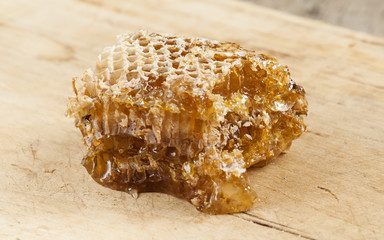 Honeycomb on old wooden table, selective focus