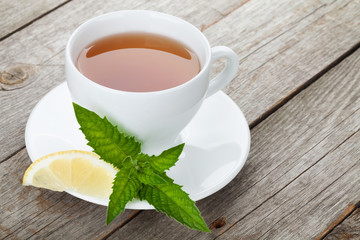 Green tea with lemon and mint on wooden table