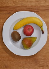 Obstteller mit Kiwi, Apfel, Birne und Banane