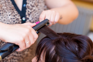 Coiffeur che prepara la  acconciatura della sposa