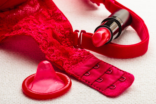 Lipstick and condom with lace lingerie.