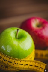 Green and red apples with measuring tape