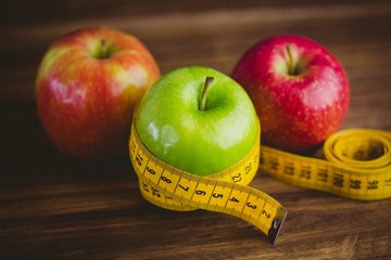 Green and red apples with measuring tape