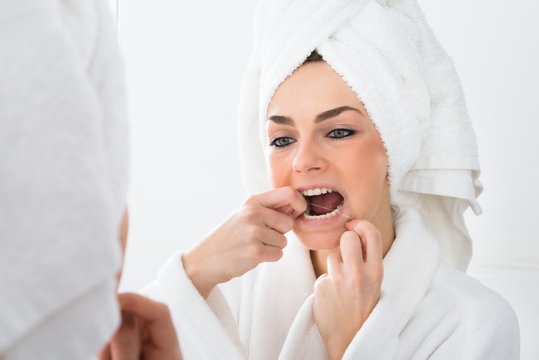 Woman Flossing Teeth