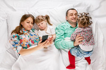 Happy mother and the father with cute daughters