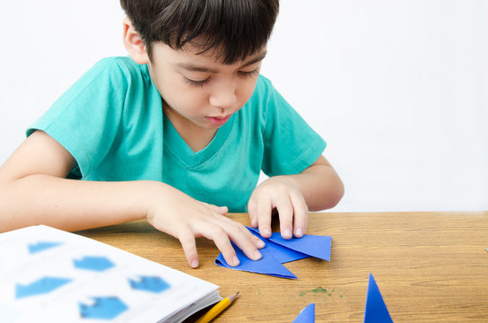 Little boy drawing on paper art origami