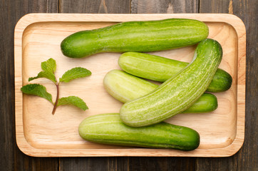Fresh cucumber on wooden plate