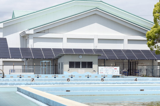 小学校の体育館とプール　屋根に設置した大型のソーラーパネル