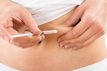 Obraz na płótnie Canvas Patient Making Insulin Shot By Use Of Syringe