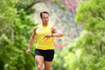 Running man looking heart rate monitor smartwatch