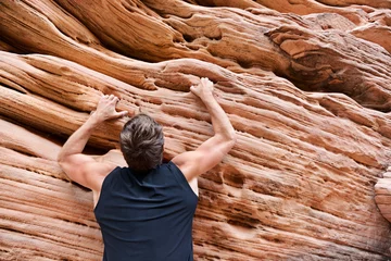 Fotobehang Climber man free climbing on rock © Maridav