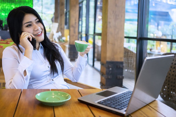 Female worker talking on the phone in cafe