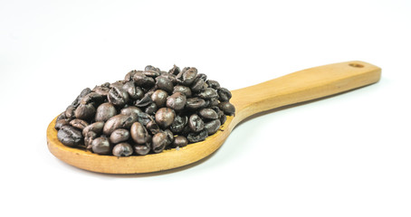 Coffee beans on a wooden ladle.