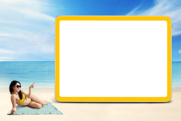 Young woman with bikini and blank billboard