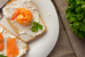 Wheat bread toasts with cream cheese, smoked salmon and shrimp