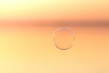 bubble flies over the water at sunset