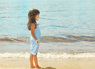 Pretty little girl walking on the beach near sea, summer, vacati