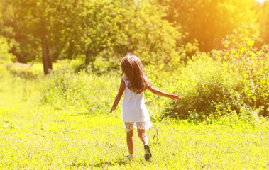 Naklejka na ściany i meble Silhouette of a little girl run on the field on a sunny summer d