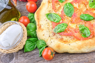 Rustic italian pizza with mozzarella, cheese and basil leaves