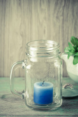 Blue candle in bottle glass
