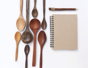 Blank notebook with wooden spoon set on white background