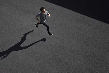 Photo sur Plexiglas Jogging Top view athlete runner training at road in black sportswear.