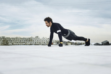Naklejka premium Athletic man doing push ups before going for a run