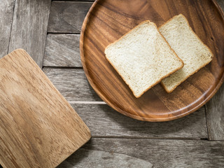 Toast bread on wooden plate and wooden breadboard