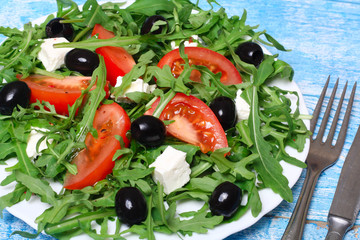 healthy salad of arugula, cheese, tomato and olives