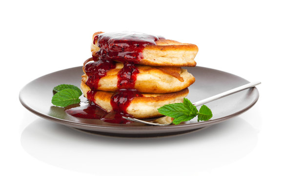 Delicious pancakes with raspberries sauce isolated over white ba
