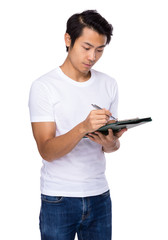 Naklejka premium Asian man write on clipboard