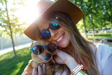 Beautiful young woman looking at camera with her dog. - obrazy, fototapety, plakaty