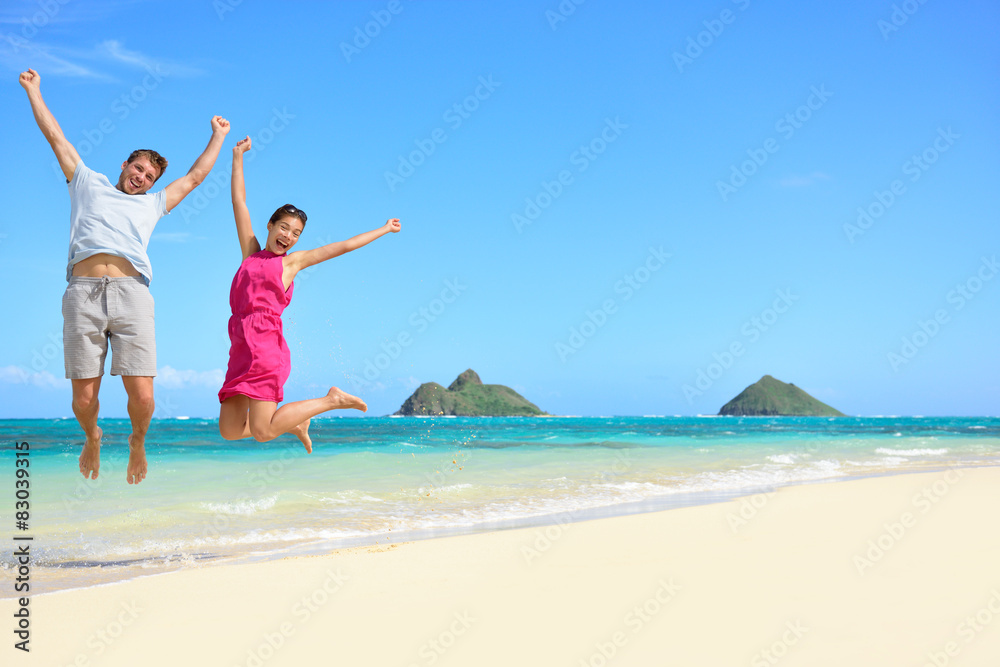 Wall mural happy fun tourists couple jumping beach vacation