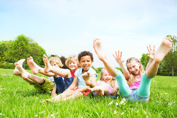 smiling kids on green grass - obrazy, fototapety, plakaty