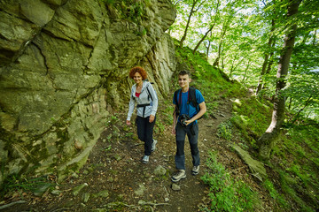 Naklejka na ściany i meble Family of hikers walking on a mountain trail