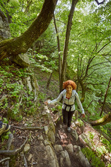Naklejka na ściany i meble Redhead woman walking on a mountain trail