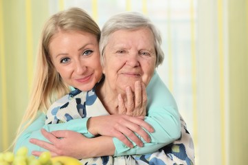 Senior woman with her caregiver. Happy and smiling.