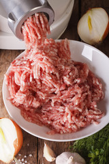 Cooking minced using a meat grinder close up vertical top view

