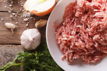 Raw minced meat and ingredients on the table. top view
