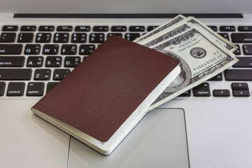 Passport with us dollars on laptop