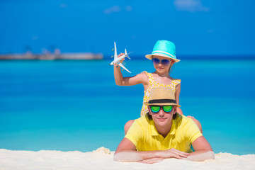 Young man and little girl with miniature of airplane at beach