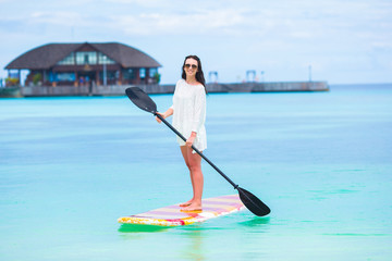 Active young woman on stand up paddle board