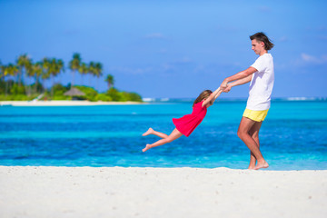 Little cute girl and dad during tropical beach vacation