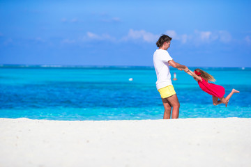Obraz na płótnie Canvas Little cute girl and dad during tropical beach vacation