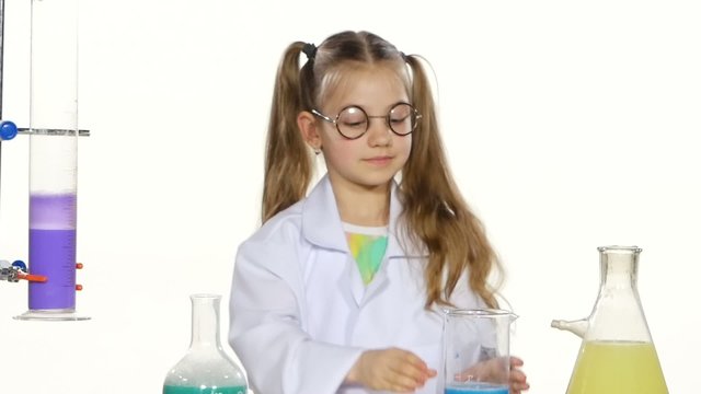 Cute girl with ponytails in uniform and round glasses evaluates