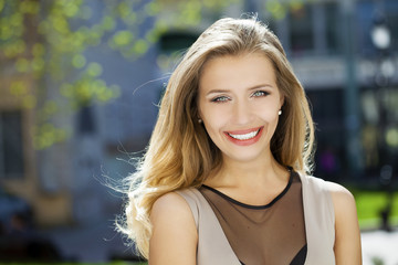 Portrait close up of young beautiful blonde woman, on background