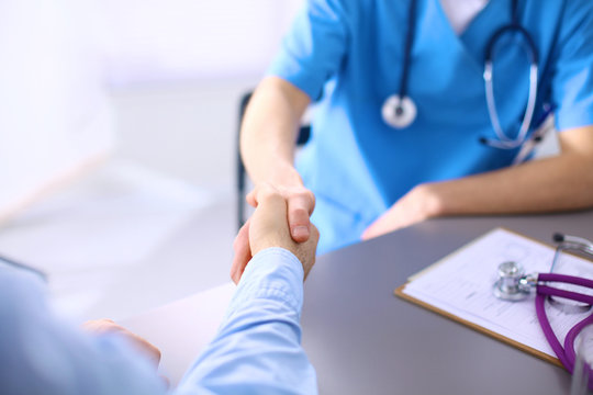 Doctor Shakes Hands With A Patient Isolated On White Background